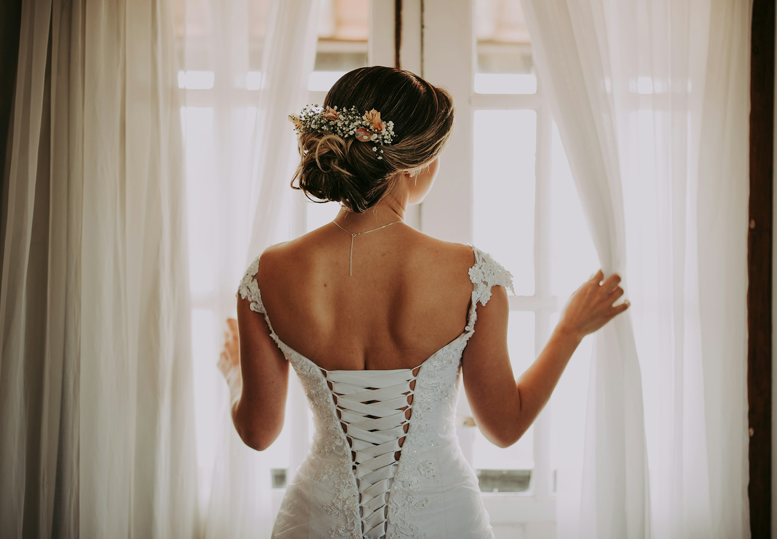 Bride standing by a window